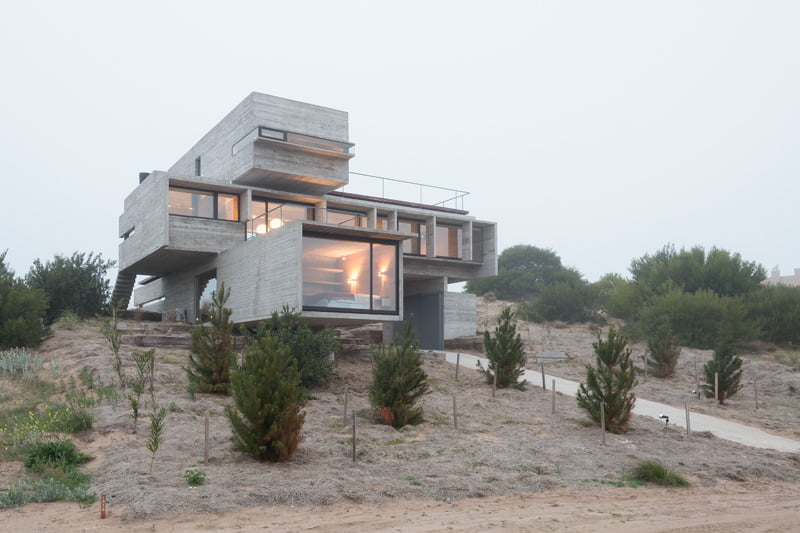 exposed concrete modern house with golfcourse view on cliff side