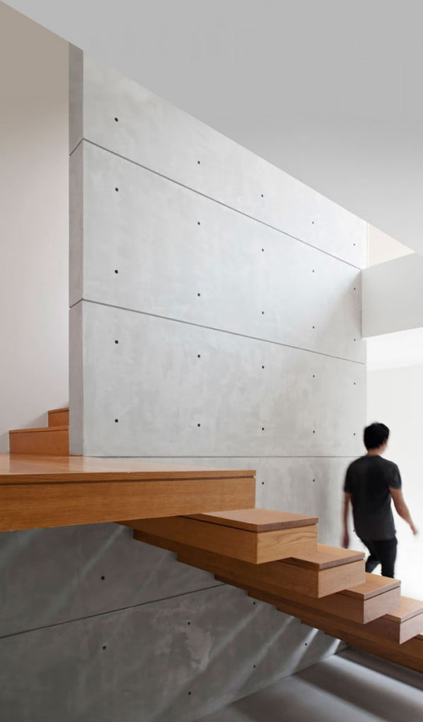 Wooden finished staircase with exposed concrete wall