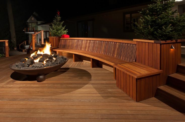 Outdoor deck design around fire pit and circular wooden bench ideas